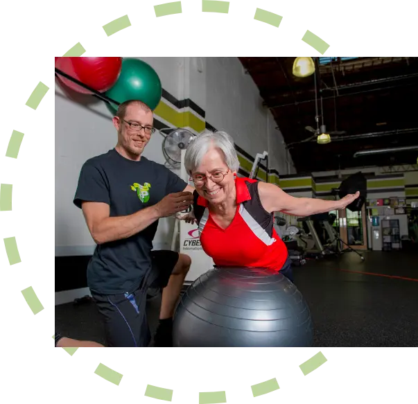 Fitness Plus personal trainer helping an over 50 year old female do back exercises
